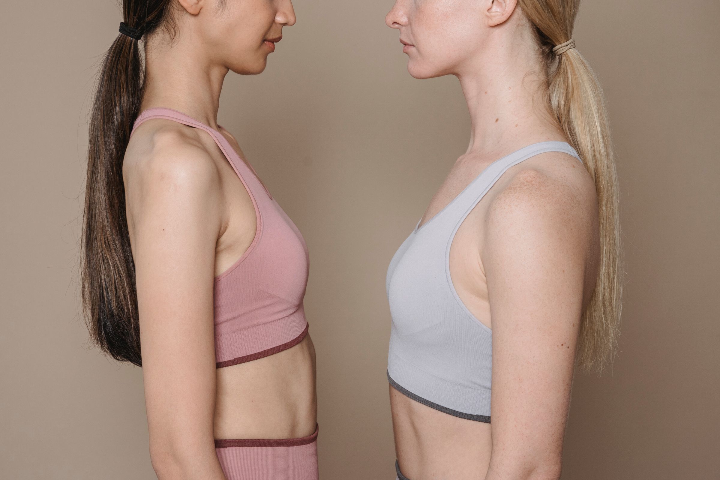 Two women in sports bras facing each other
