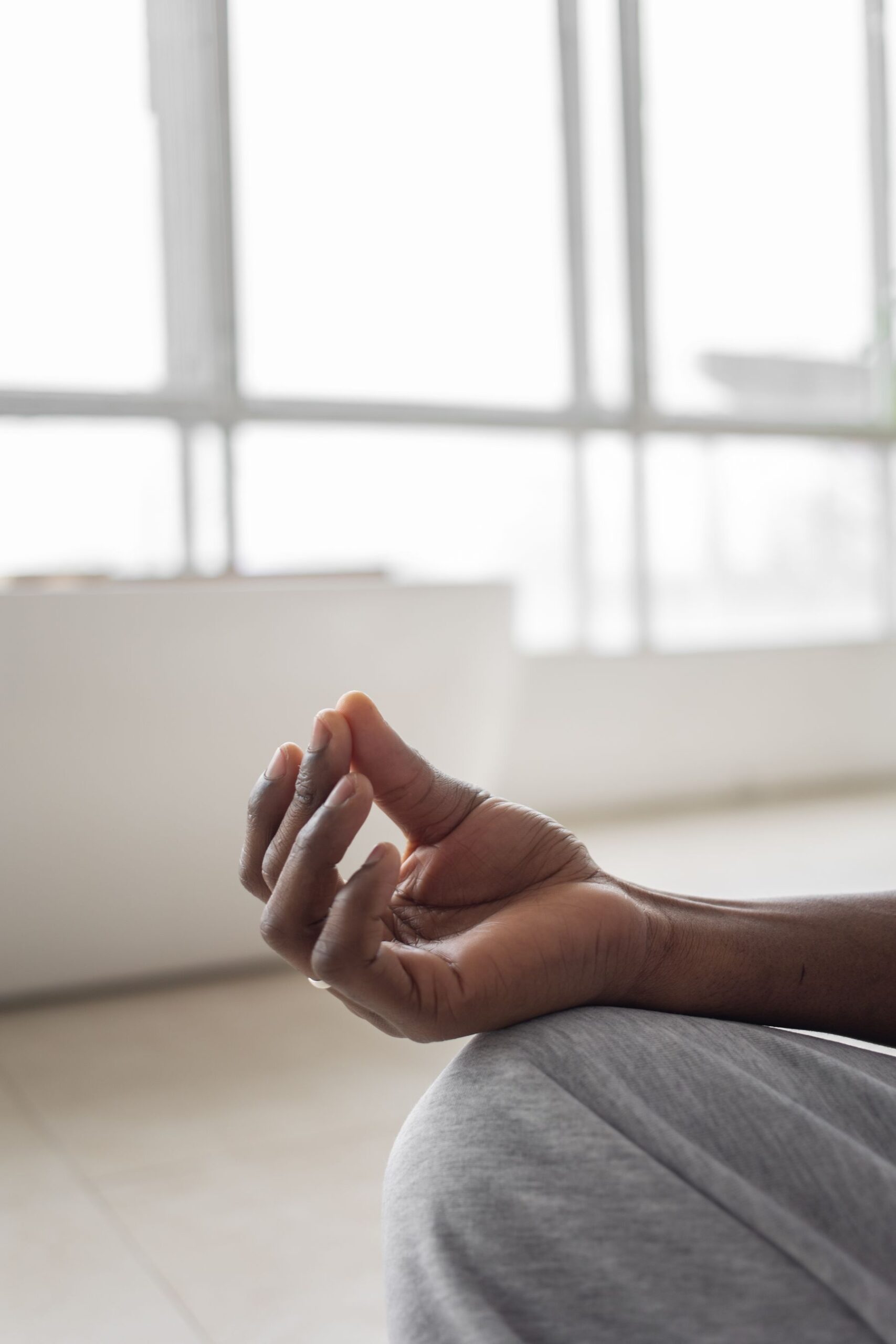 Hand resting on knee in meditation